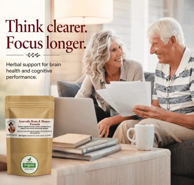 Two elderly people sitting on a couch with a laptop, holding papers, and a package of herbal supplement on a table. BRAIN & MEMORY FORMULA - Herb Man Teas